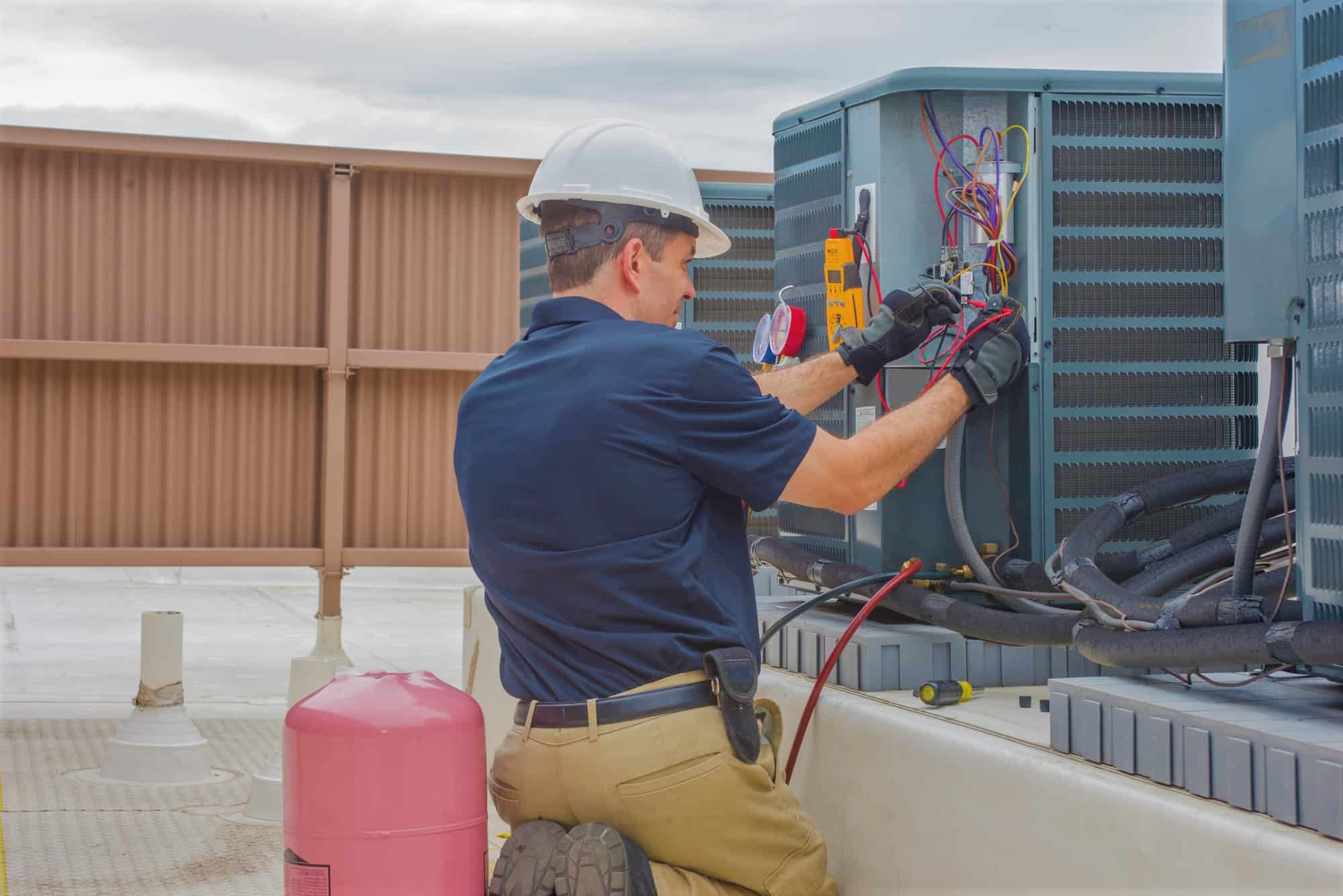 Technician checking for power on a rooftop condensing unit